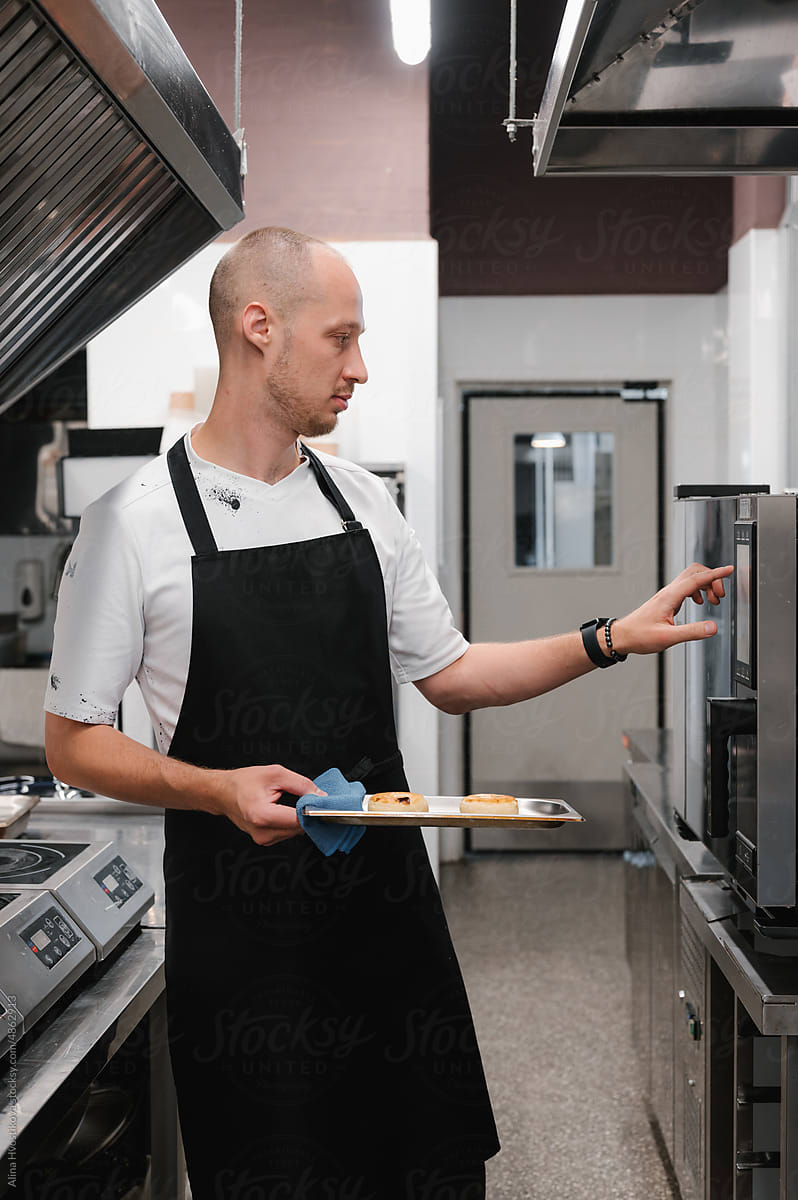 Man setting oven controls in restaurant