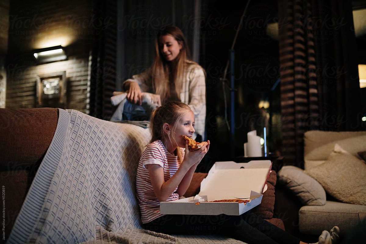 girl eating pizza and watching tv