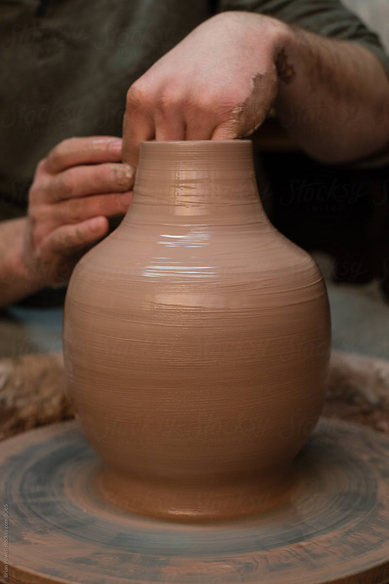 closeup of potter hands and vase on wheel
