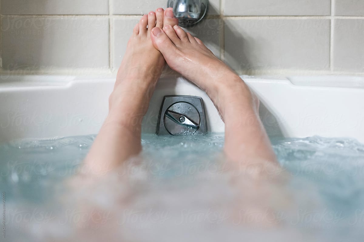 Woman\'s bare feet relaxing in a hot, bubbling bathtub
