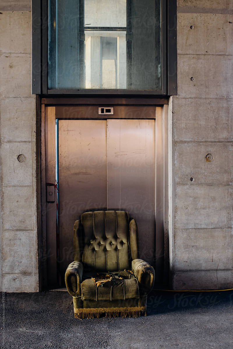 Abandoned Green Sofa in Front of Public Elevator