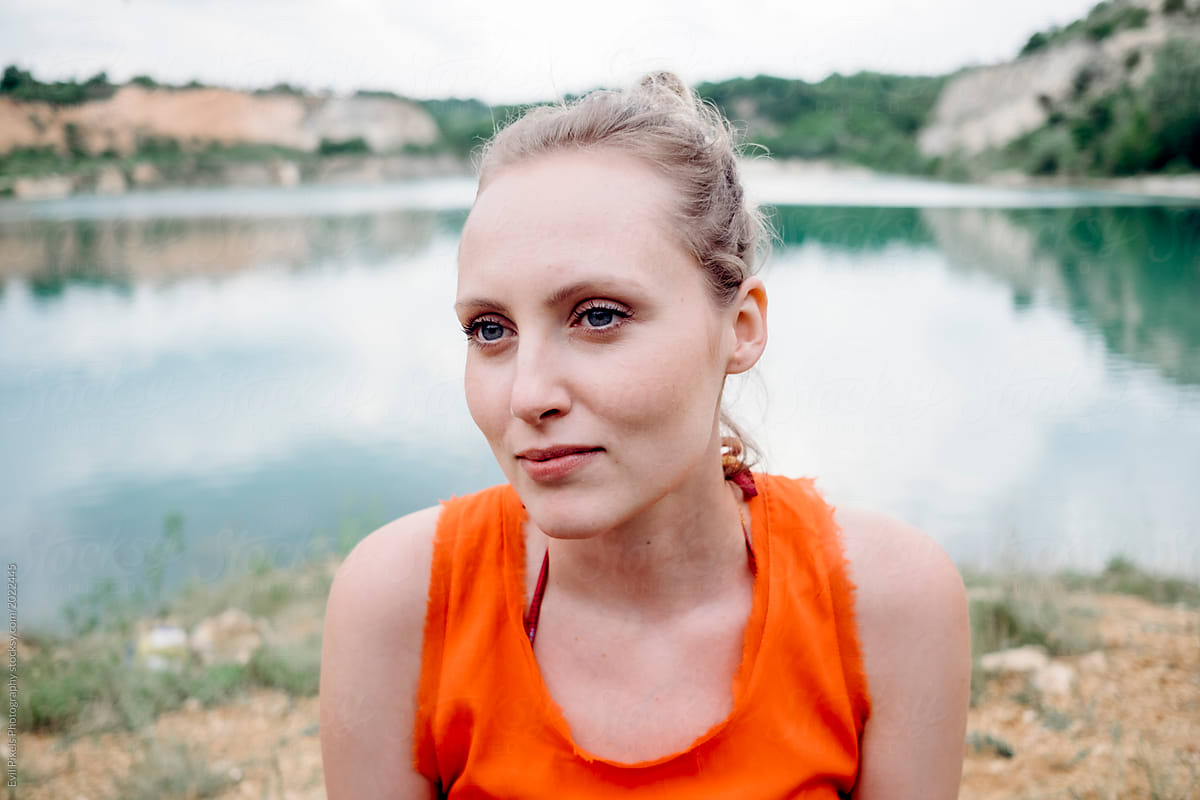 Portrait of a female model in orange t-shirt near the lake