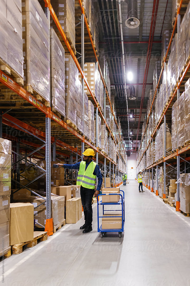 Black storage worker scanning boxes goods warehouse