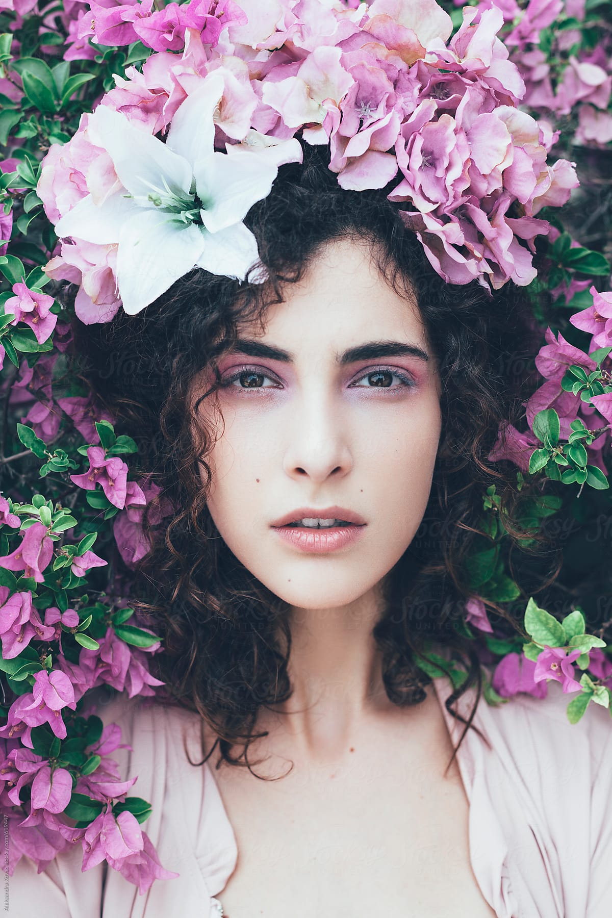 Woman beauty surrounded by pink flower arrangement.