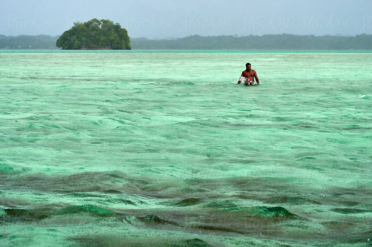 Pacific Islander man half-naked in ocean waters - Sea level rise