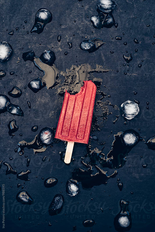 Food: Homemade strawberry popsicle on black background with ice cubes