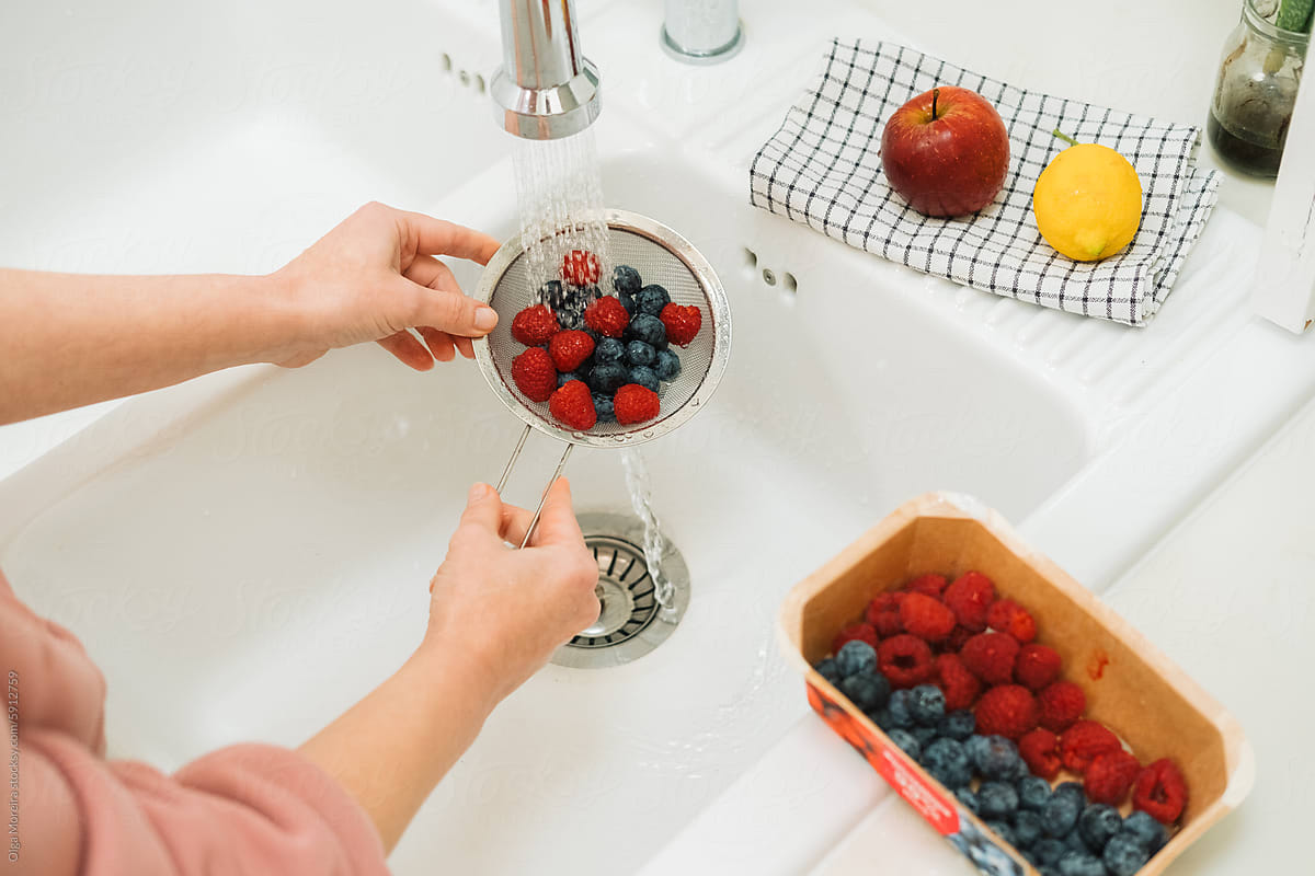 Female hands washing berries