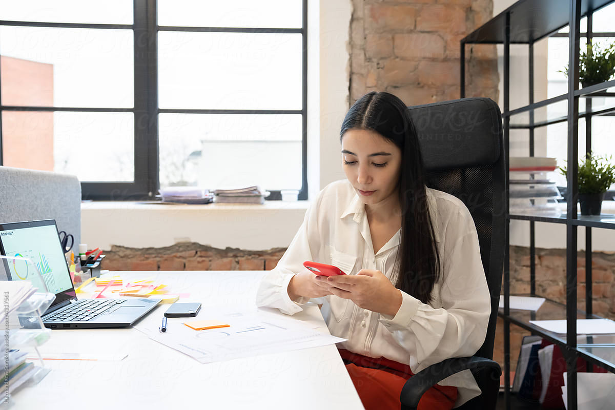 Woman Using Phone At Workplace