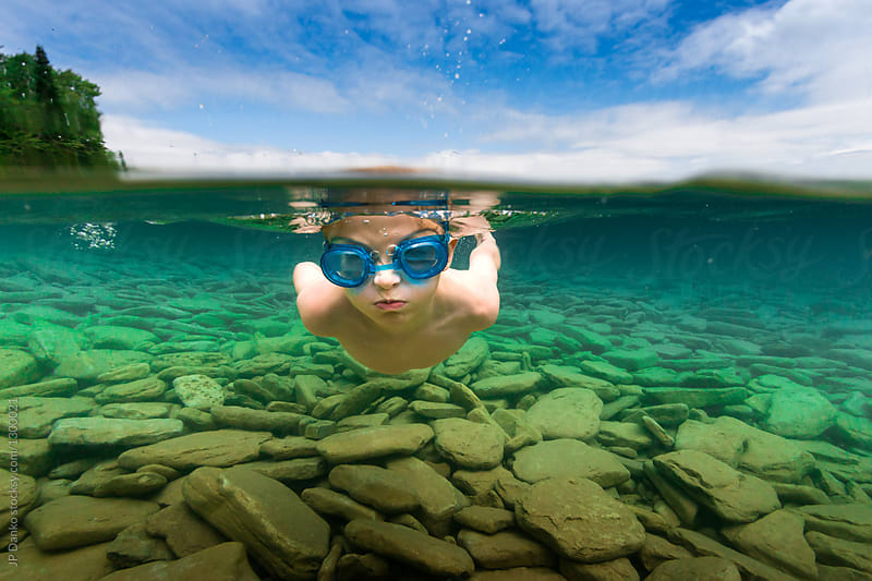 Over Under Boy Swimming Underwater In Summer Lake