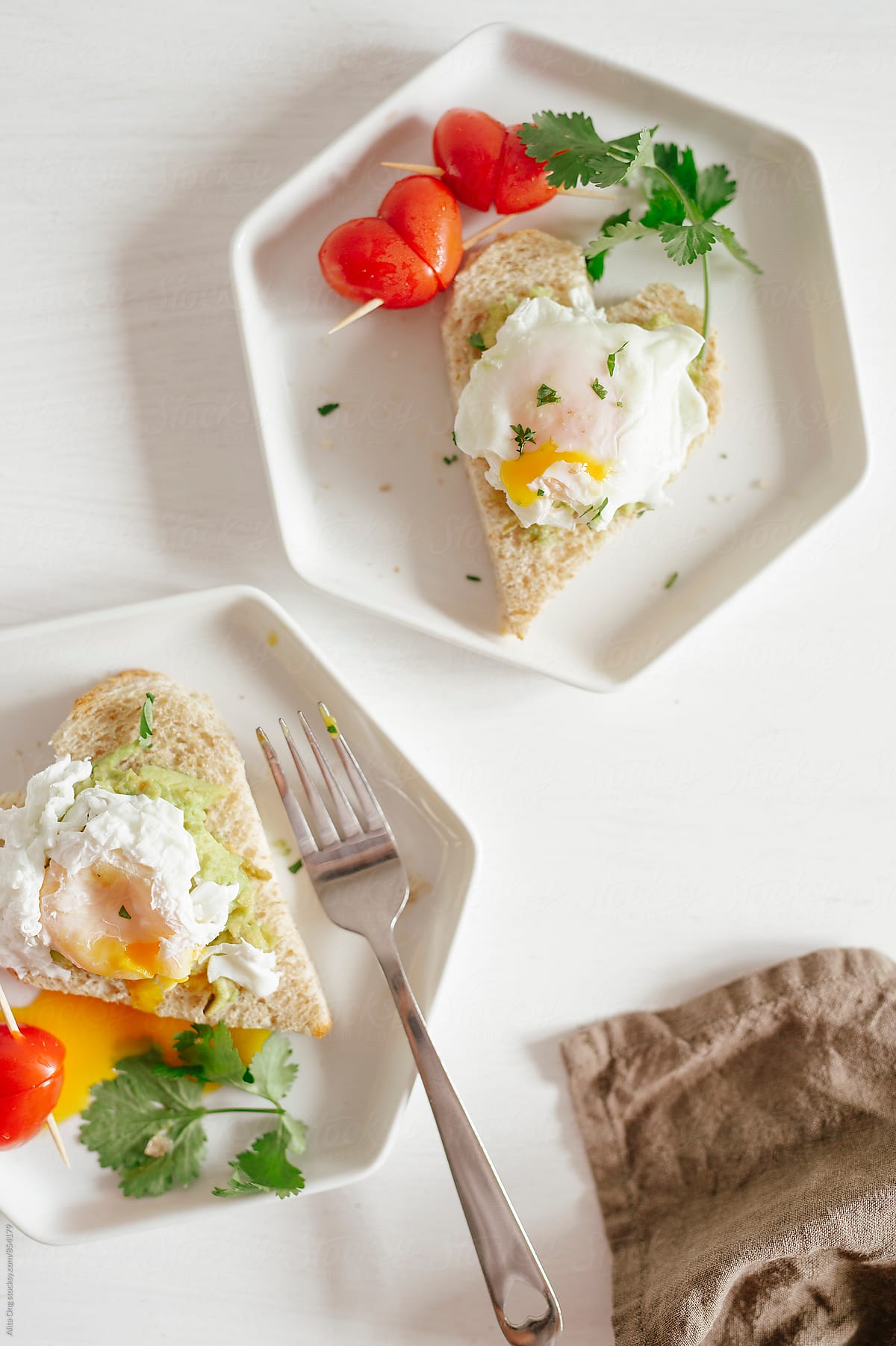 Heart-shaped avocado toast with poached egg and cherry tomatoes