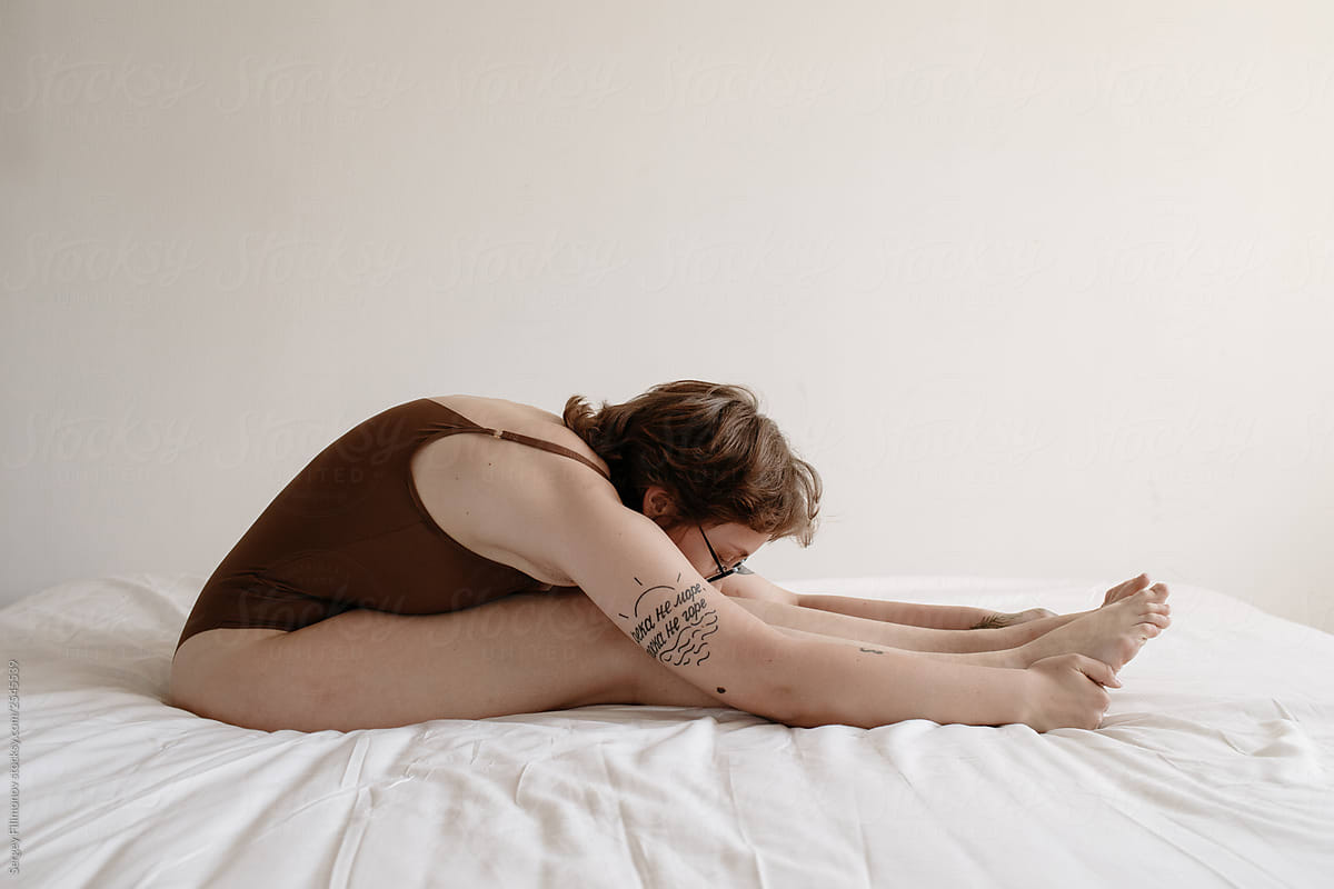 Real woman stretching body on bed