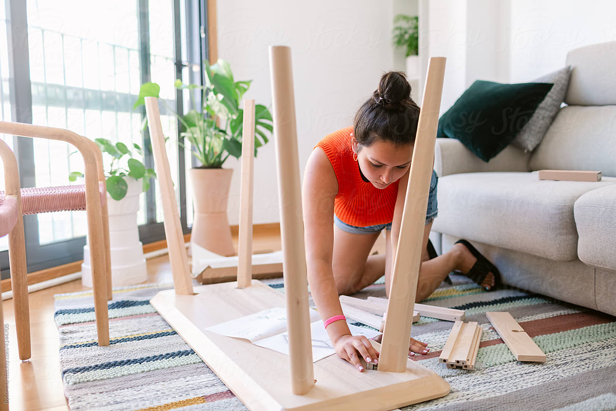Woman assembling table at home