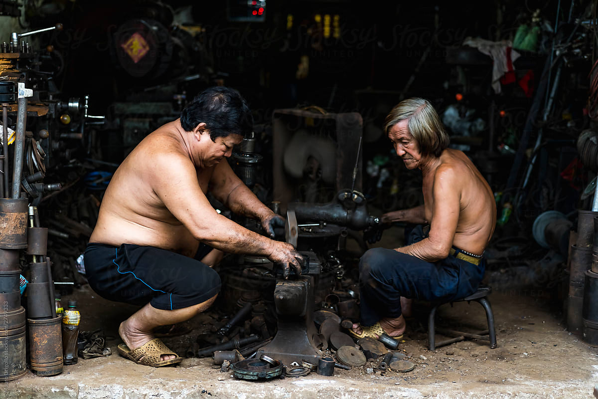 Men working in a messy mechanical workshop