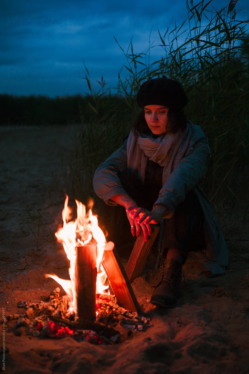 Woman warming near fire