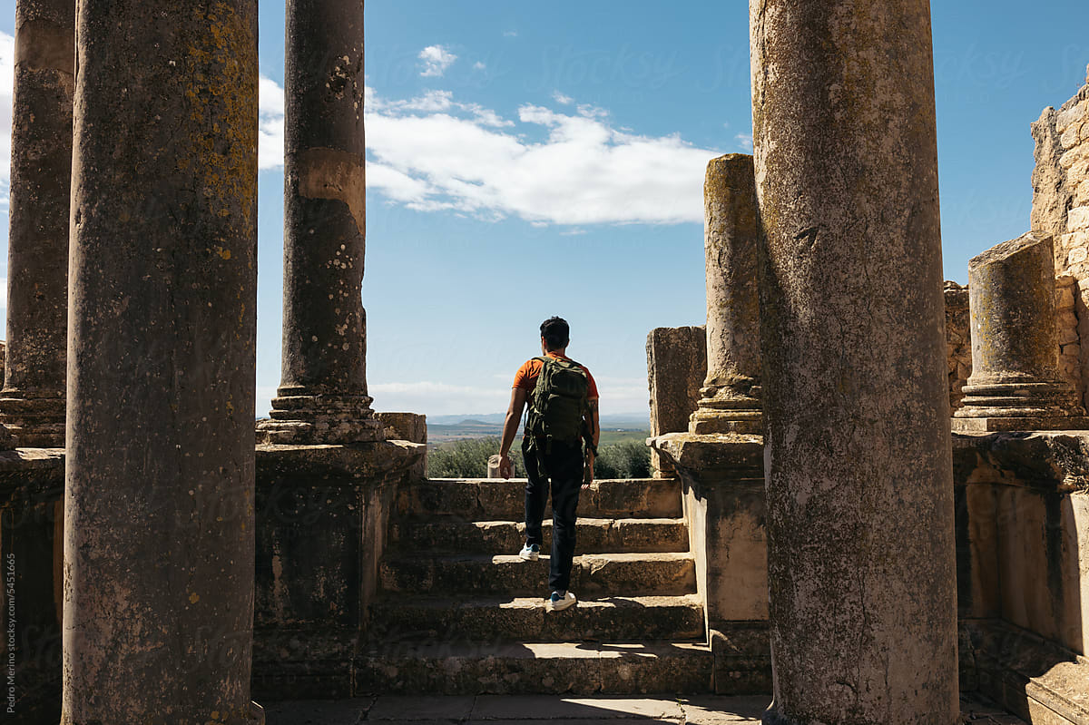 Traveler man in the roman ruins of Dougga, Tunisia