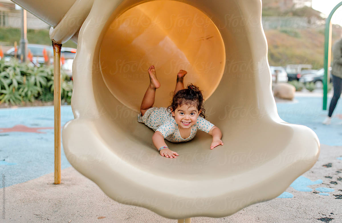 Happy young girl on belly in tube slide