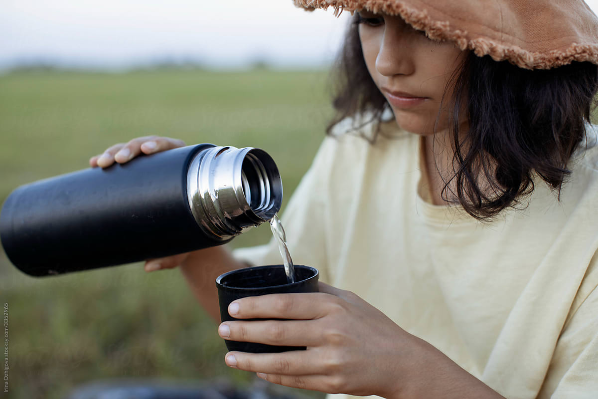 Crop Woman Pouring Hot Drink From Thermos by Stocksy Contributor