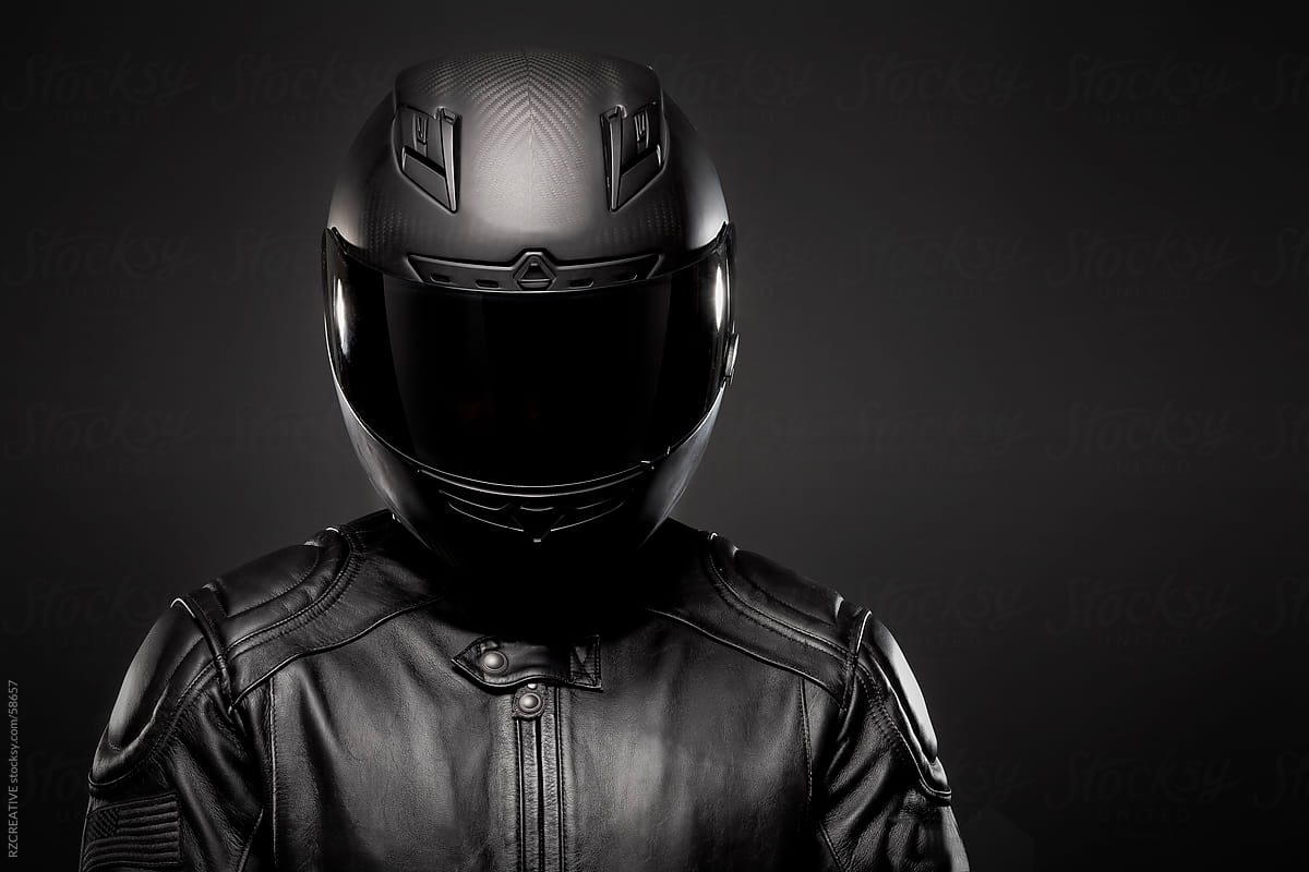 Man Wearing A Black Leather Motorcycle Jacket And Helmet On Dark