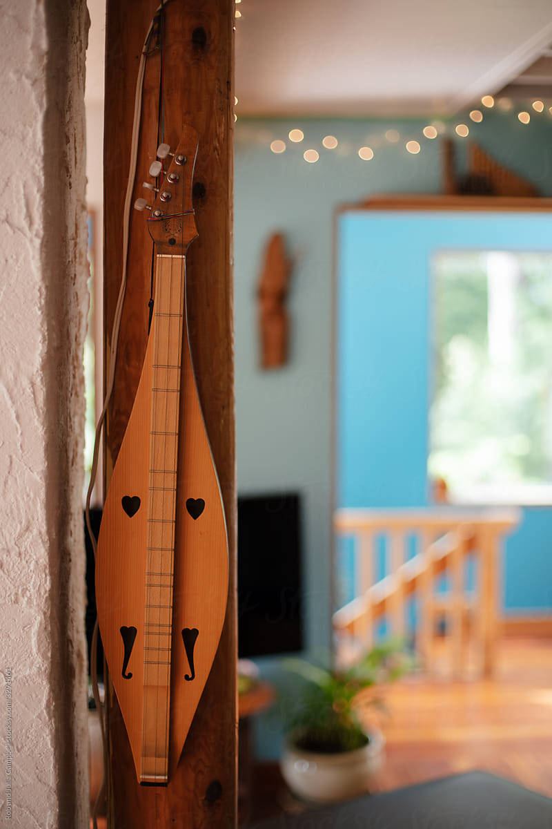 Hand made stringed instrument hanging on wall.