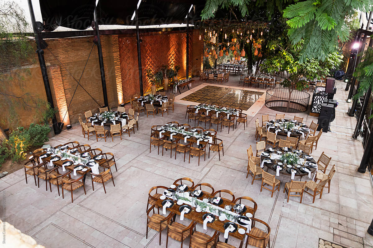 View of an empty venue with wooden tables for a wedding setup