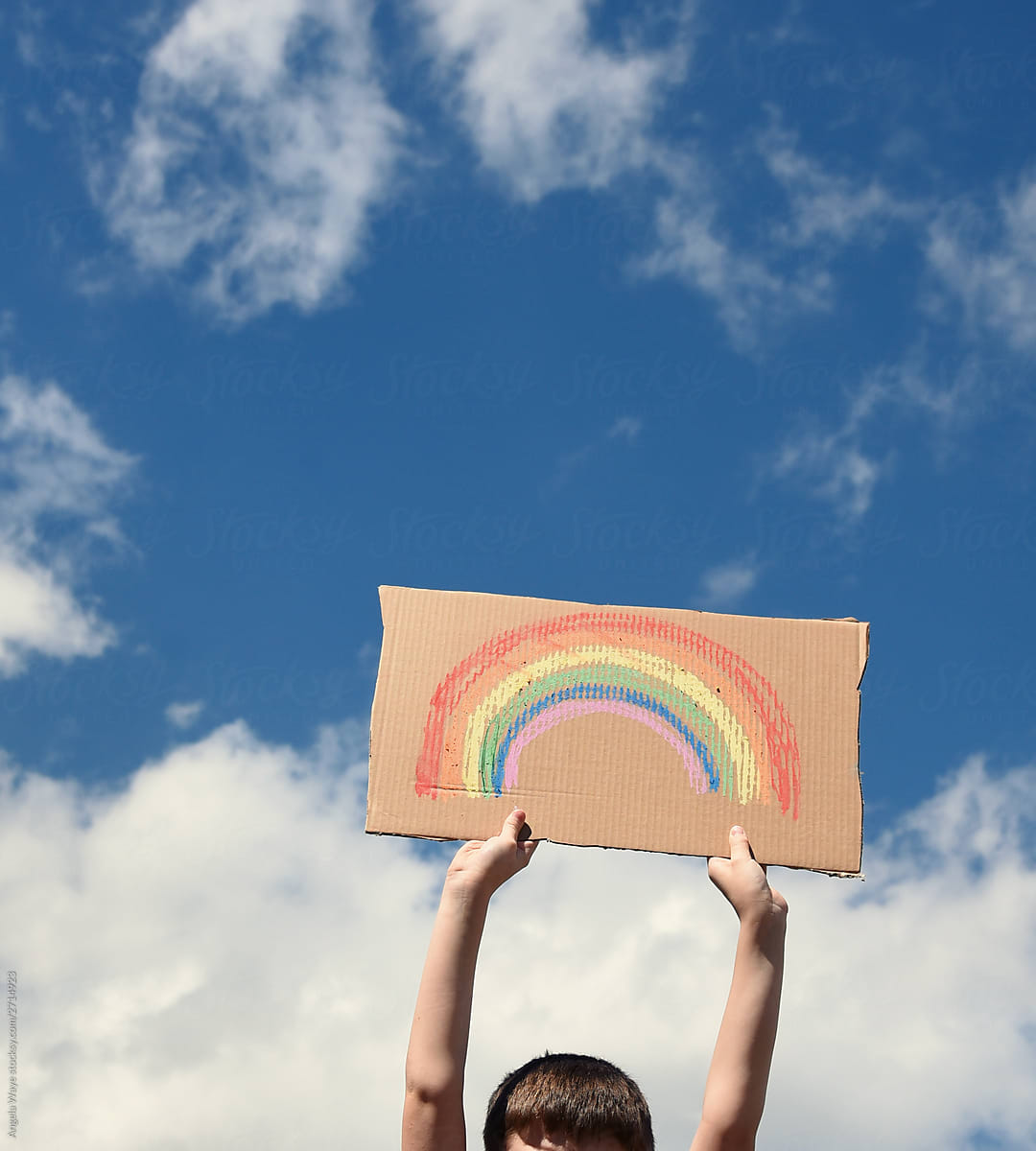 Boy Holding Rainbow Art in Sky