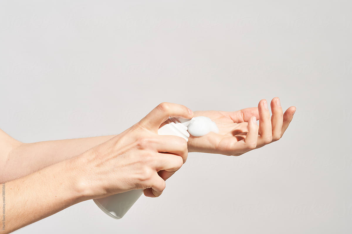 Woman putting foamy cosmetic product on hand