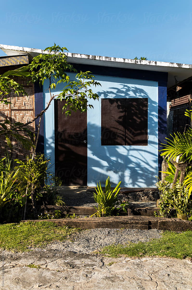 Tropical village blue house with woven bamboo walls