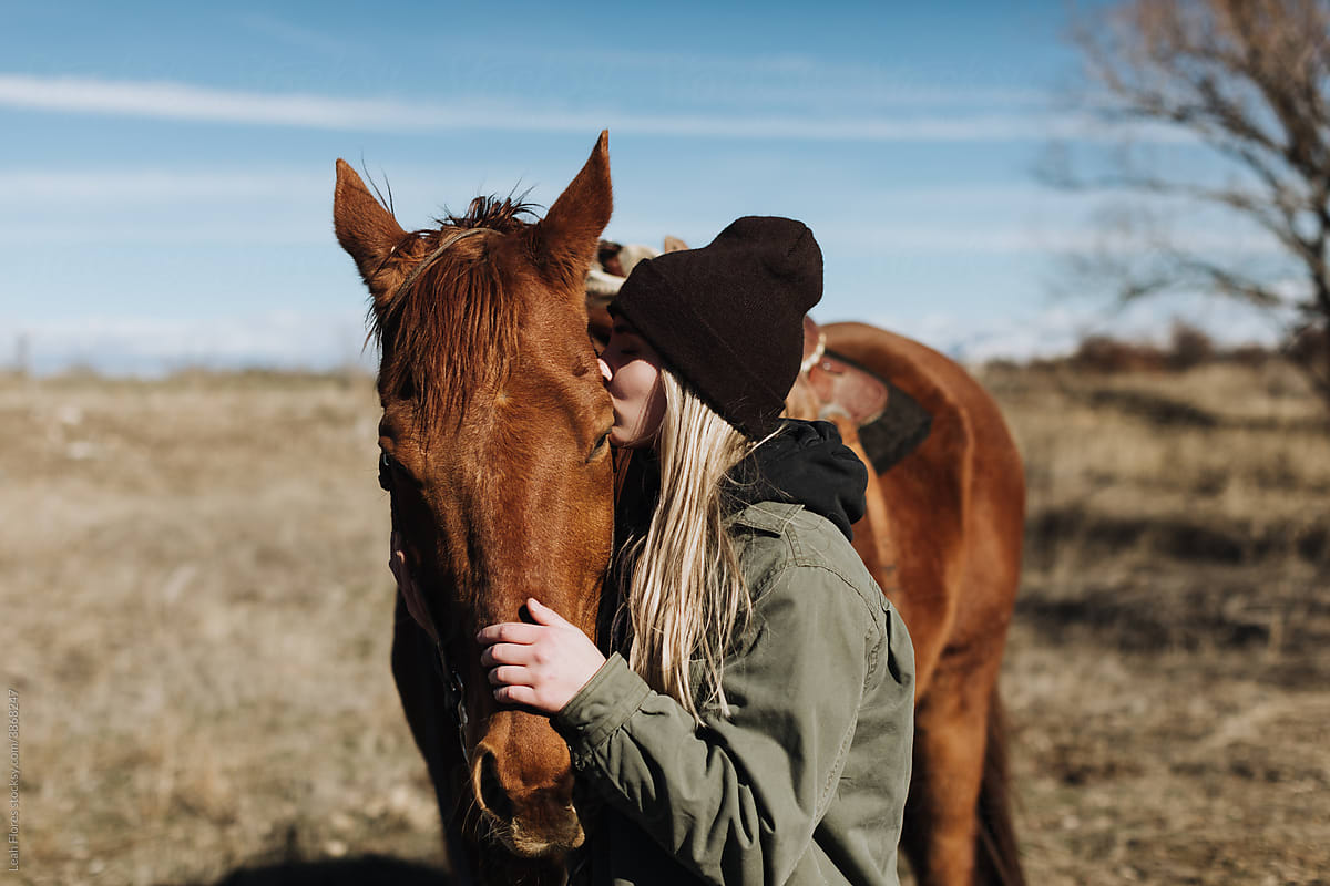 Woman Kissing Horse on Cheek