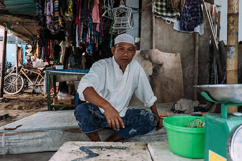 Indonesian Middleaged man runs a fish business on local market
