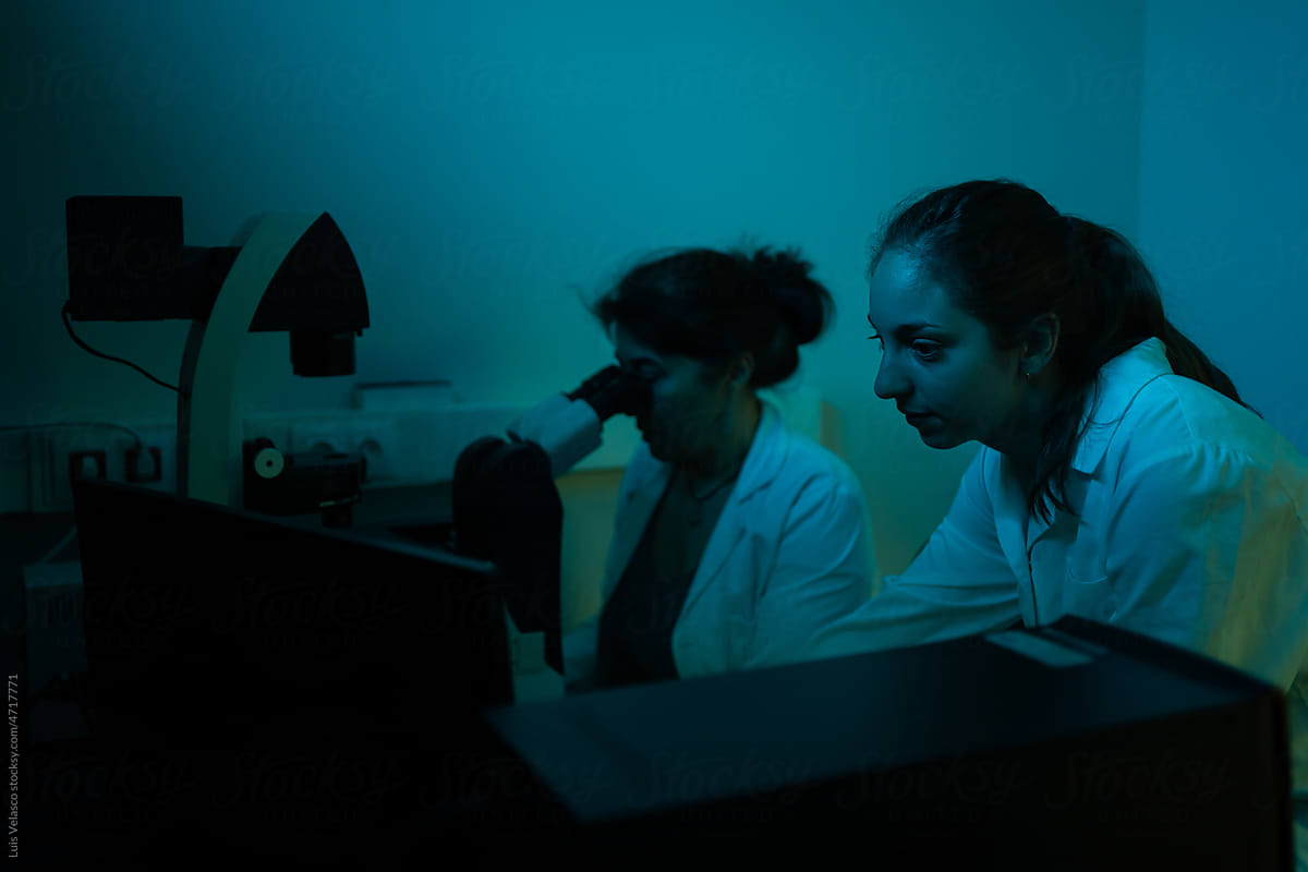 Scientists Researching In The Laboratory With Blue Lights.