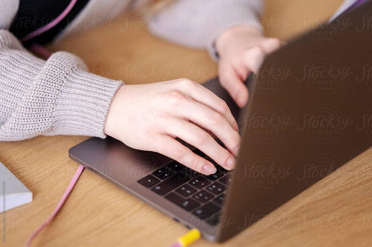 Crop teacher browsing laptop during distance lesson