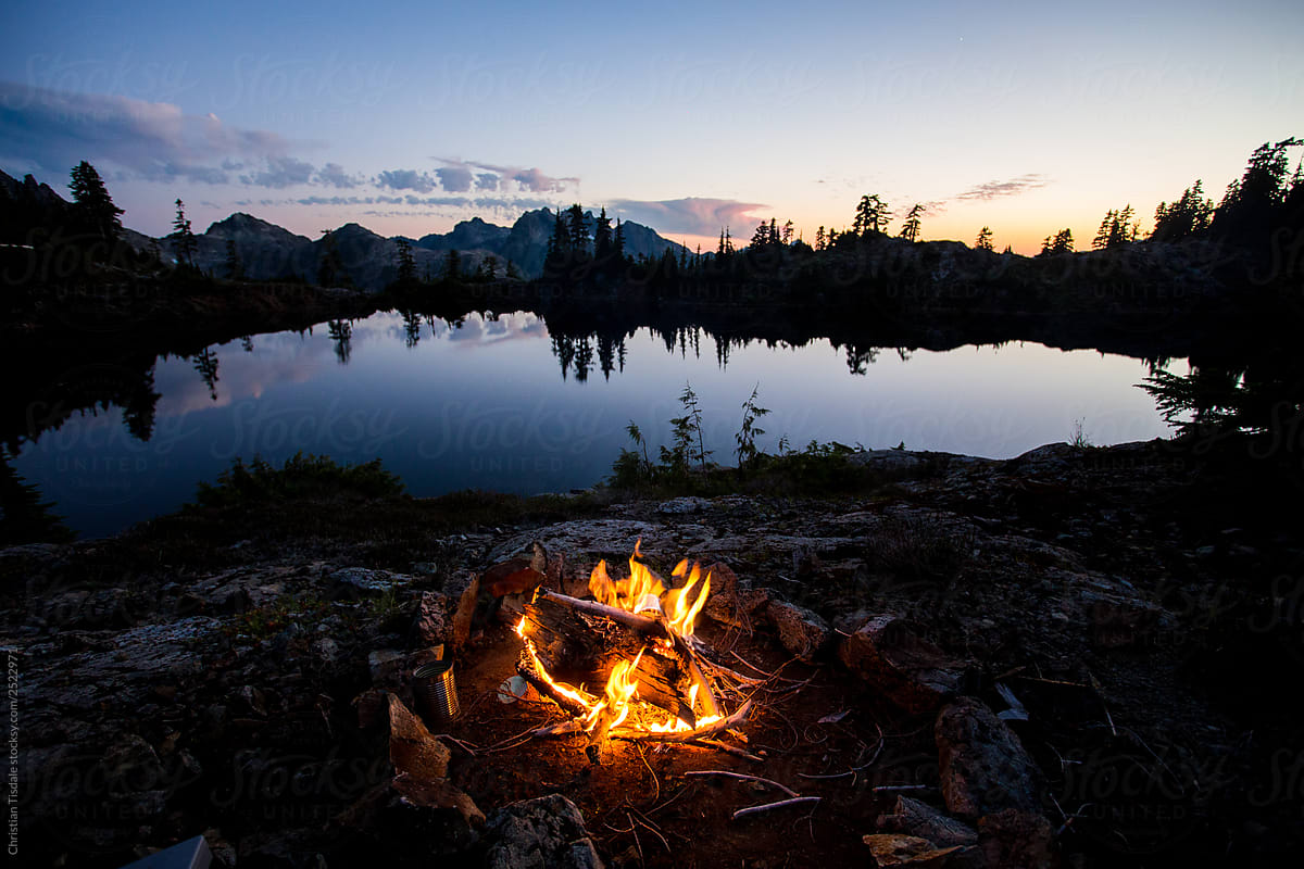 A bonfire beside a lake in the mountains