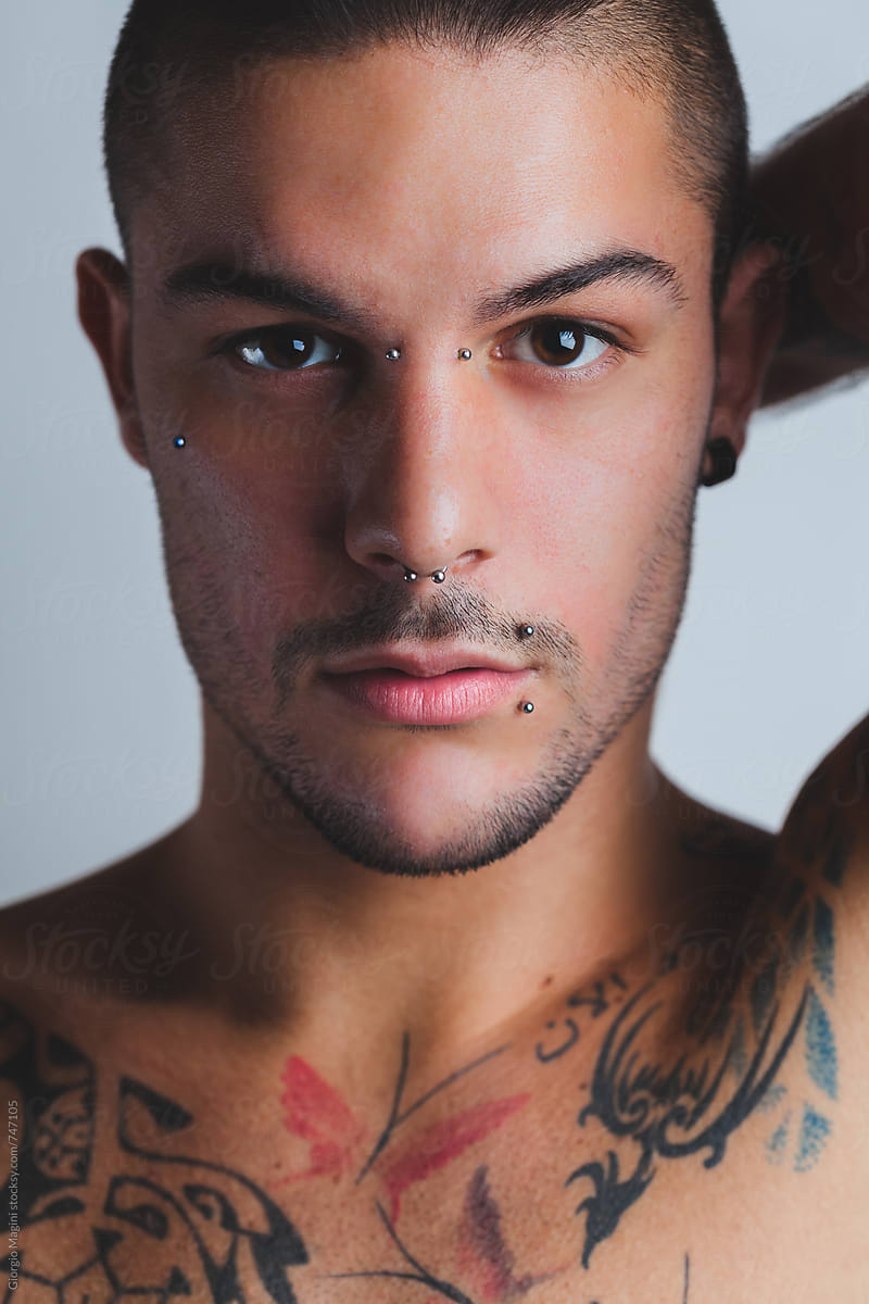 Studio Portrait of a Sexy Young Man with Piercings and Tattoos