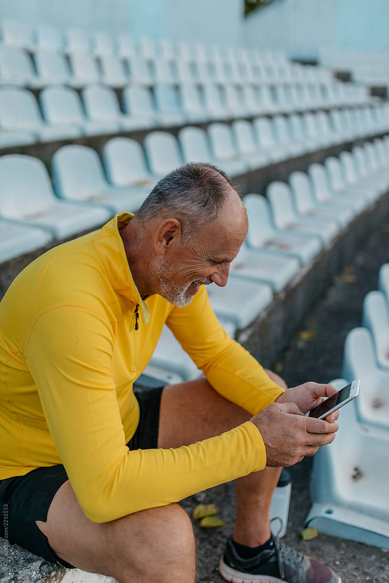 Senior sportsman with mobile phone