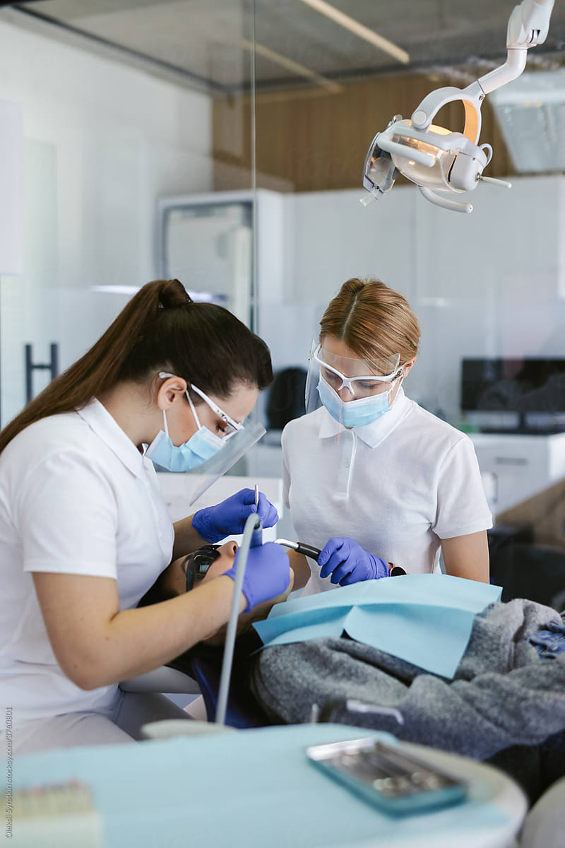 Specialists providing dental care and hygiene to client
