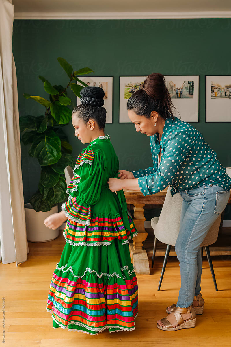 Mother helping daughter to dress up for performance