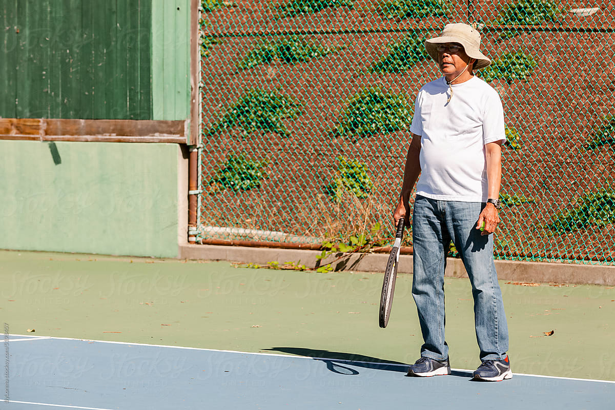 Senior man playing tennis outdoors