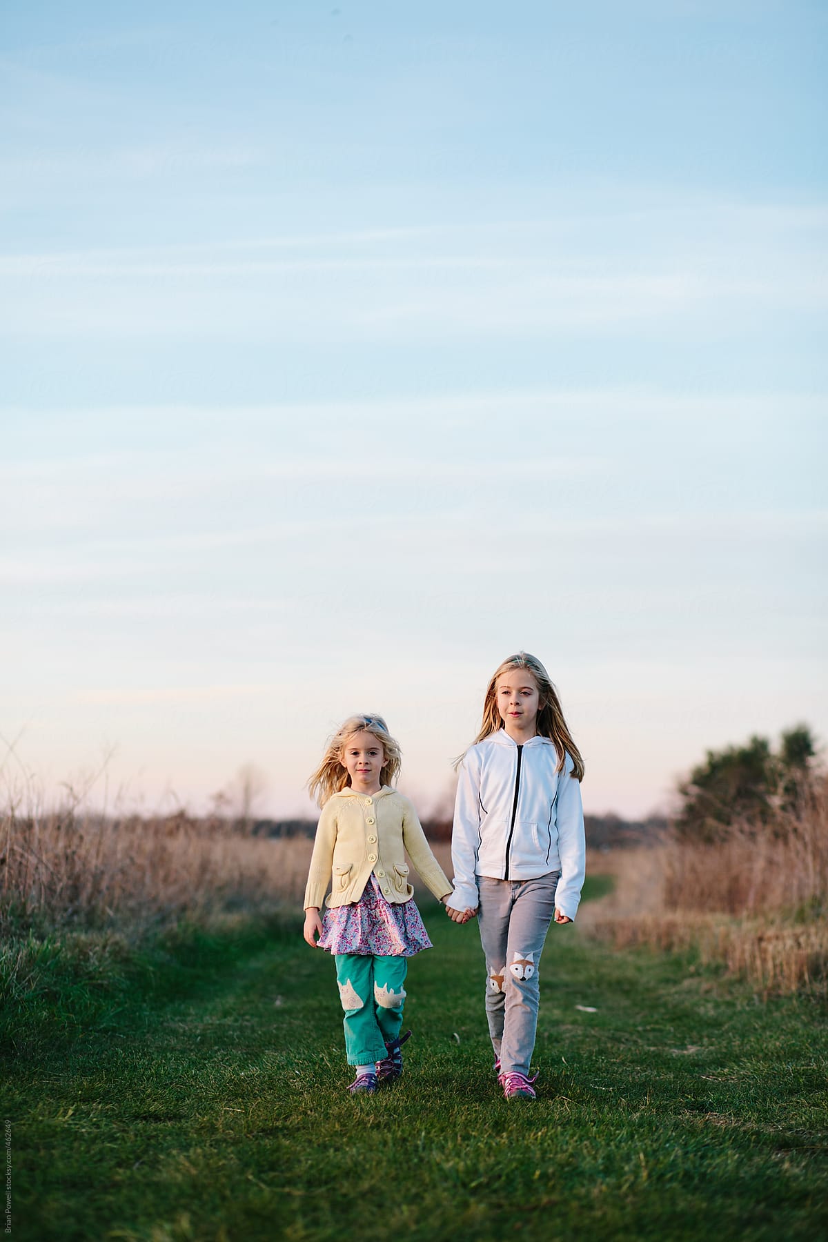Two Sisters Holding Hands By Stocksy Contributor Brian Powell Stocksy