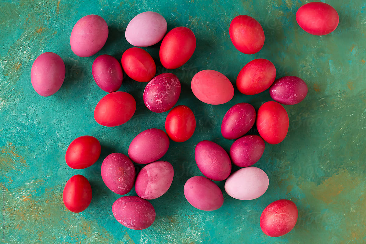 Pink and red Easter eggs on green background.
