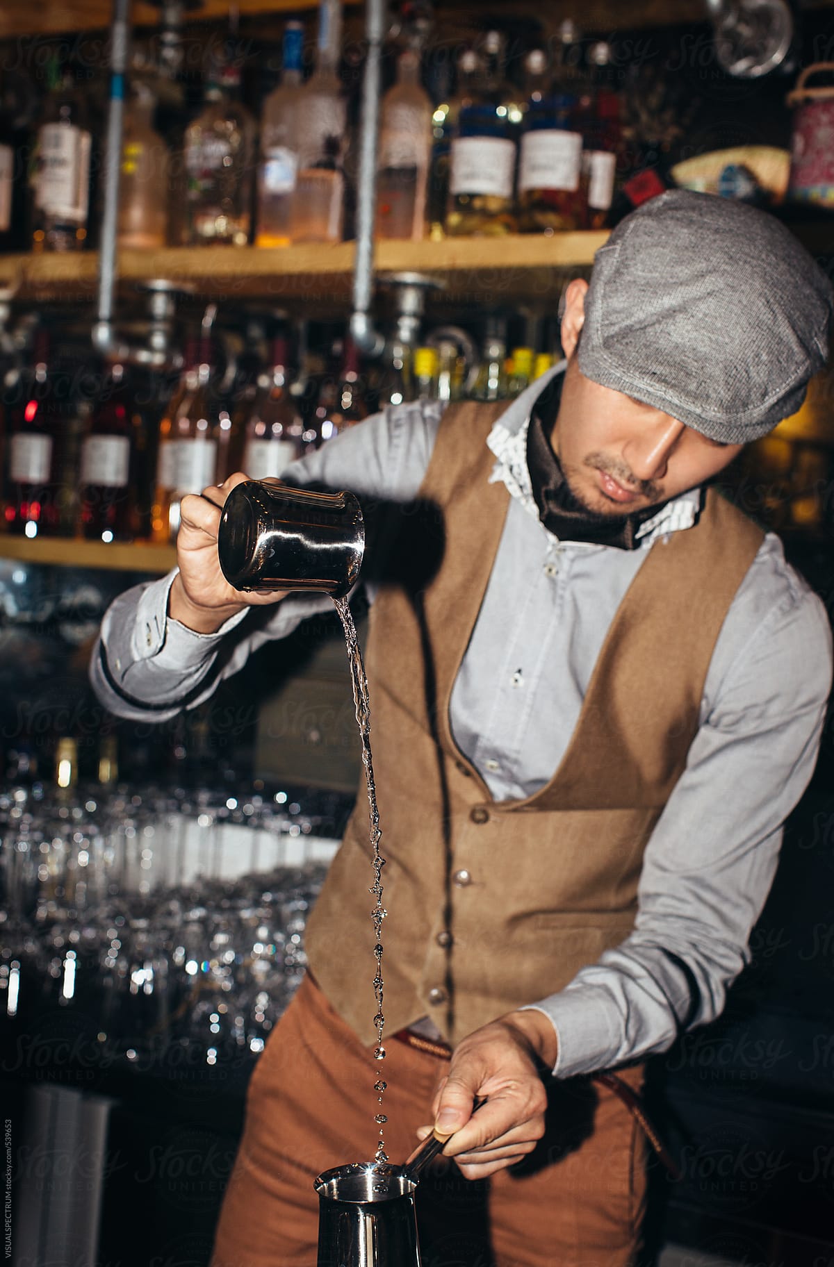 Smart Asian Barman Preparing Elaborate Drink in Dark Bar