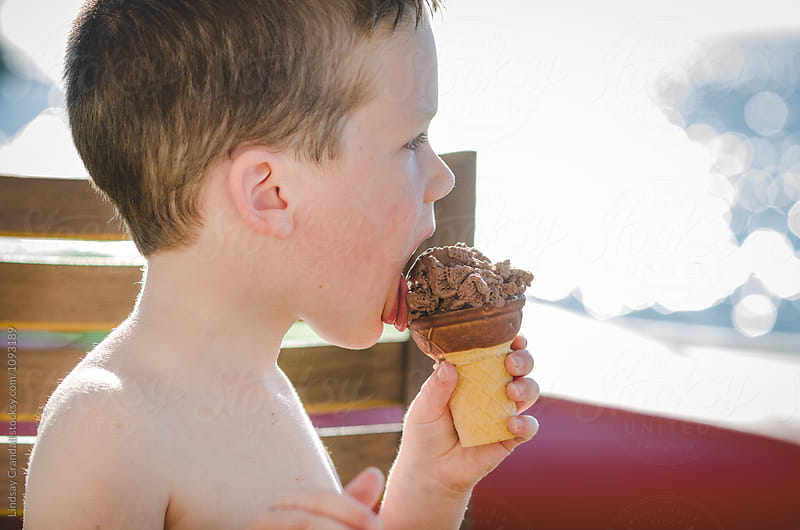 Little boy eating an ice cream cone in summer