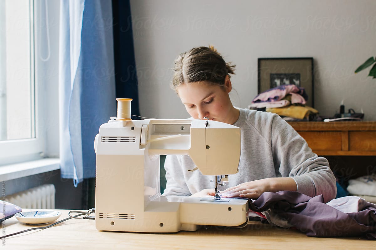 Young Caucasian Woman Working on Sewing Machine at Home