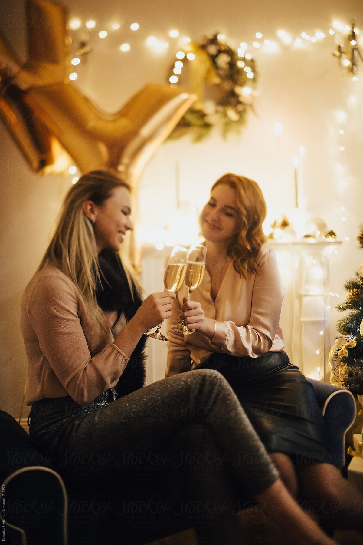 two girls celebrating New Year drinking champagne