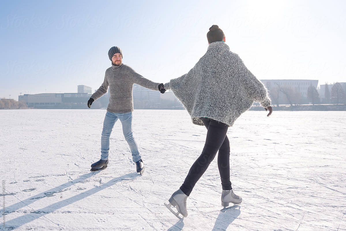 Romantic couple ice skating outdoor on the frozen lake by RG&B Images for Stocksy United