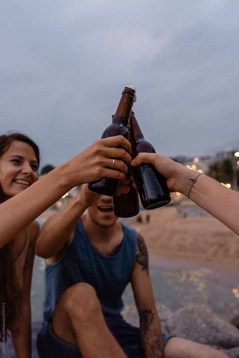 Cheerful friends proposing toast in evening on resort