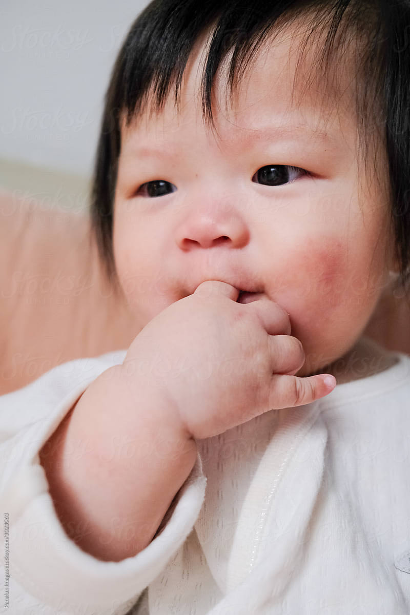 cute Asian baby licking fingers