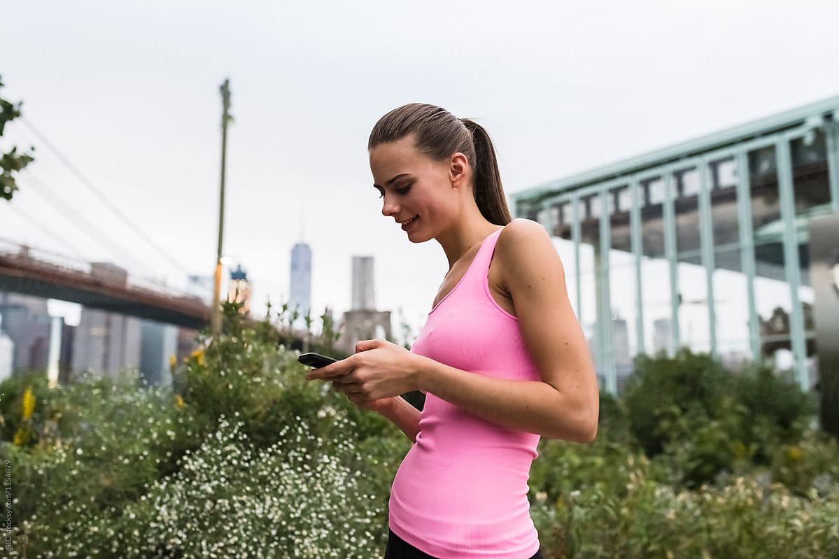 Young runner using a phone before jogging