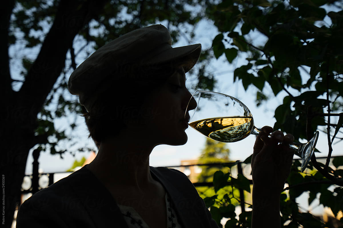 Anonymous woman drinking wine in garden