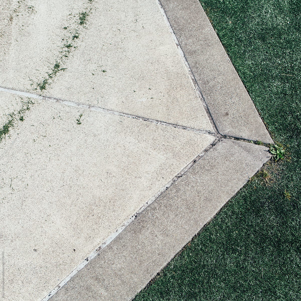 Sidewalk along edge of artificial turf sports field, close up