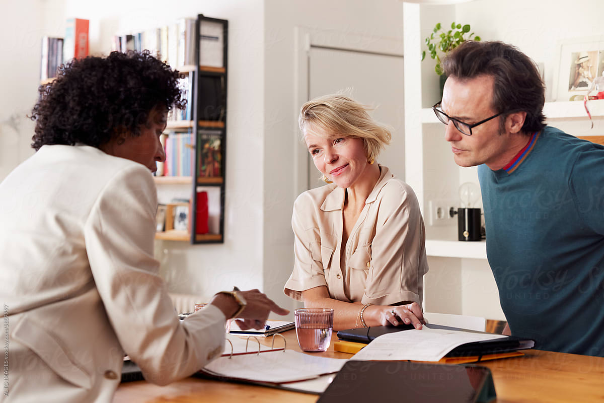 Insurance advisor discusses paper policies with couple at home